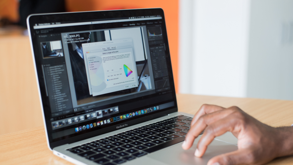 Personne utilisant un logiciel d'édition photo sur un MacBook Pro