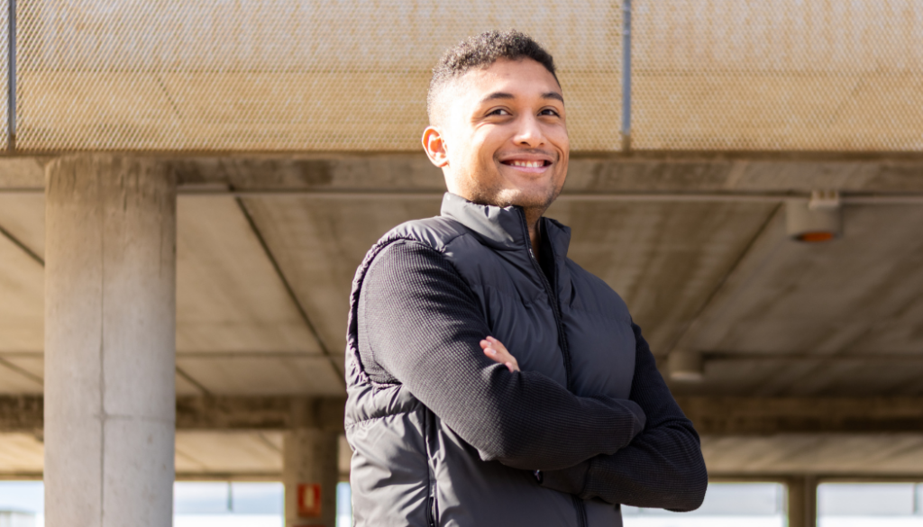 jeune homme avec les bras croisés et le sourire déterminé